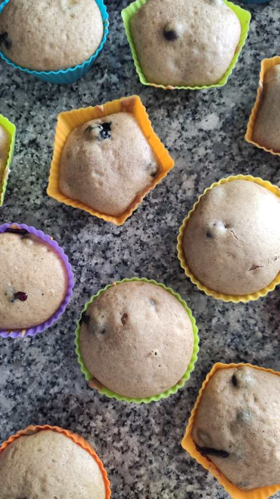 Queques de mirtilo e limão em formas de silicone coloridas, sobre uma superfície de granito.